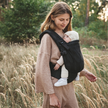 imagen de madre porteando a un bebe en la que se aprecian los detalles de ergonomia y comodidad para bebe y porteador en una mochila de porteo ergonomica y evolutiva